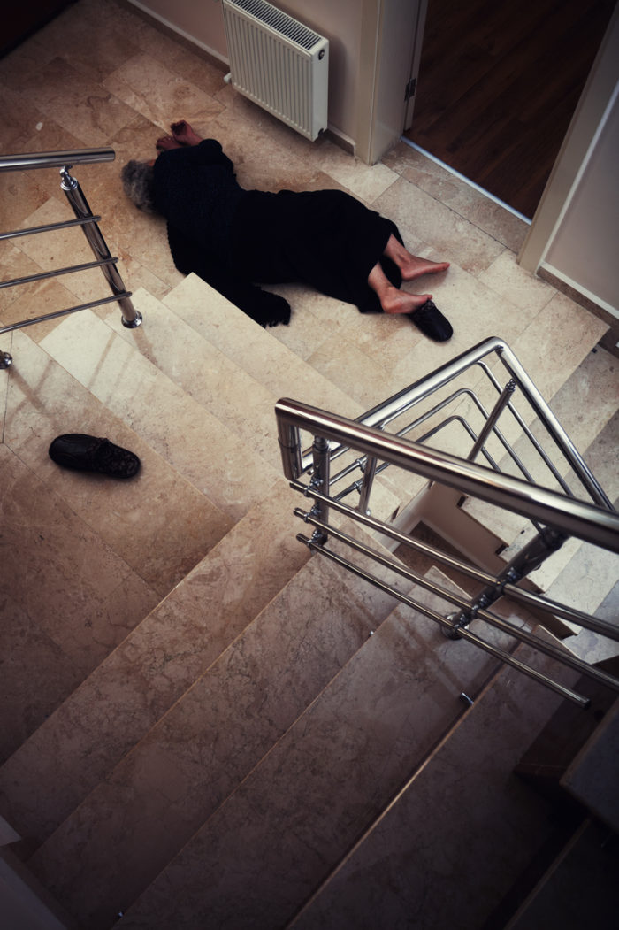 Senior woman lying on floor after falling down the stairs