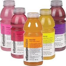Five bottles of different flavors of Vitaminwater are arranged in a group.