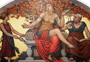Three figures in classical attire, one holding scales, seated before a backdrop of grapevines.