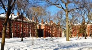 Red brick university buildings with snow-covered ground and leafless trees on a sunny day.
