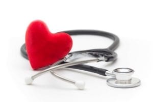 A red heart and a stethoscope placed on a white background.