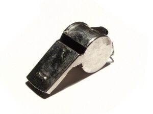A metal referee whistle on a white background.