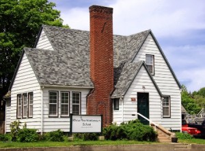 White house with a tall brick chimney and a sign reading "White Pine Montessori School.