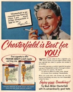 Smiling woman holds cigarette above Chesterfield cigarette ad promoting its mild flavor.