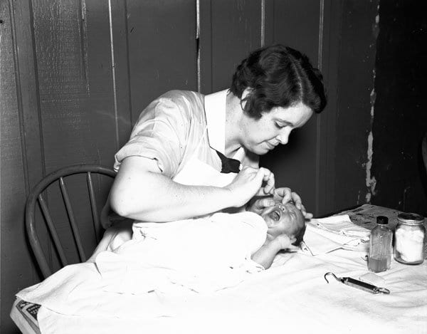 A WPA Public Nurse in New Orleans (1936) administering eye drops to an infant. 