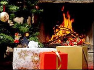 Presents under a decorated Christmas tree beside a fireplace with a burning fire.