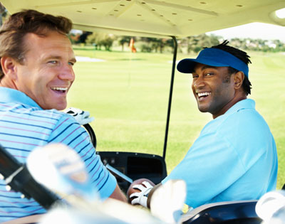 Two men smiling in golf cart