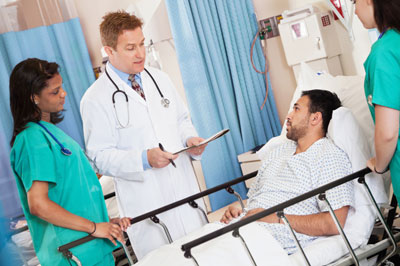 Doctor and nurses talking to a patient in bed