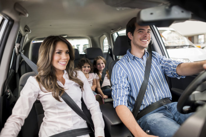 Family driving a car and looking very happy