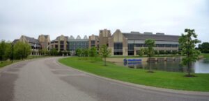 Medtronic office building with pond and trees on a cloudy day.