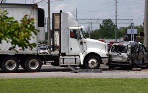 A semi-truck and a minivan damaged in an intersection tractor trailer accident.