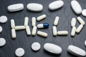 Pills spelling "HELP" highlight the struggle and urgency of opiate addiction.