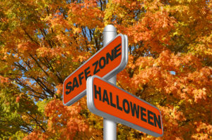 Two orange street signs read "SAFE ZONE" and "HALLOWEEN," promoting Halloween safety.
