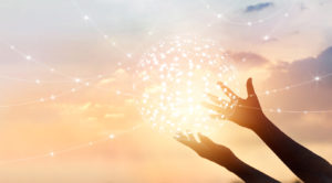 Two hands hold a glowing Net Neutrality network sphere against a sunset sky.