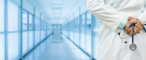 Doctor holding stethoscope in hospital hallway, addressing opioid concerns.