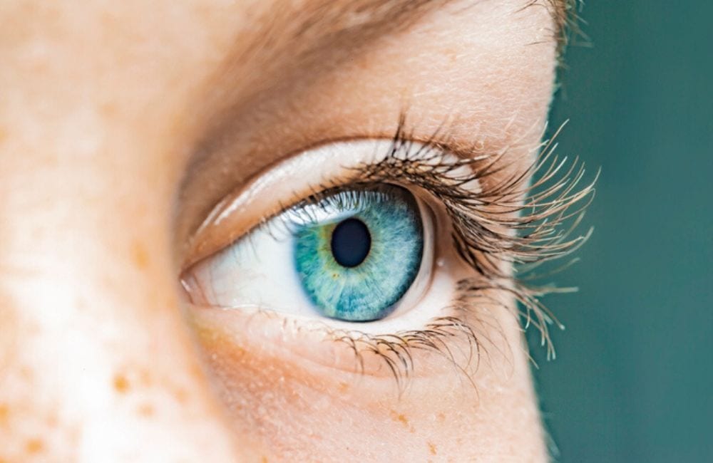 A closeup shot of a fair-skinned woman's eye, which is light green. Many women who took Elmiron are at risk for developing retinal maculopathy.