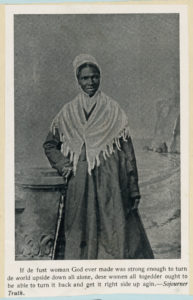 Black-and-white photo of Sojourner Truth standing outdoors, wearing a shawl and bonnet.