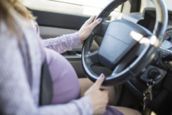 pregnant woman driving a car buttoned up belt