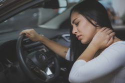 Female driver rubbing her aching neck after long drive