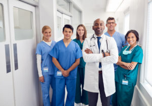 A group of healthcare professionals pose together in a hospital corridor.