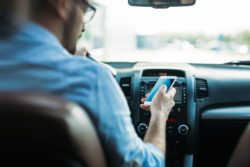 man using phone while driving the car