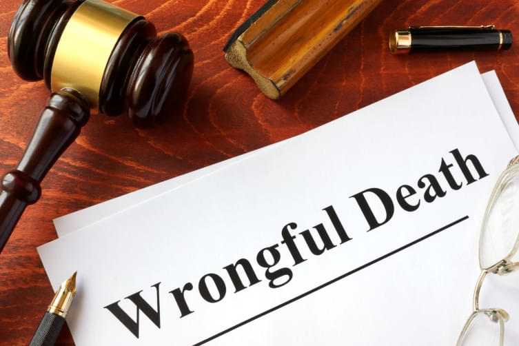 Wrongful death form on table next to court gavel pen and glasses