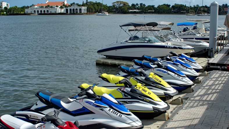 A row of jet skies boats and watercraft along a pier on a bay in West Palm Beach Florida