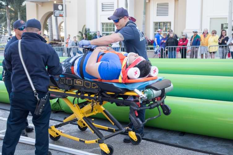 Man being rolled away on a stretcher by paramedics after catastrophic injury on water slide in west palm beach Flordia