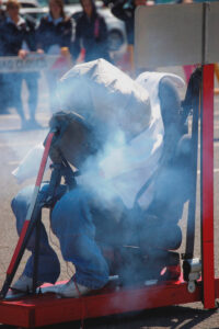 Crash test dummy seated, takata airbag injuries demo, smoke rising after airbag deployed.