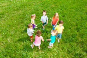 Seven children stand in a circle, holding hands—life is more unfair for some than others.