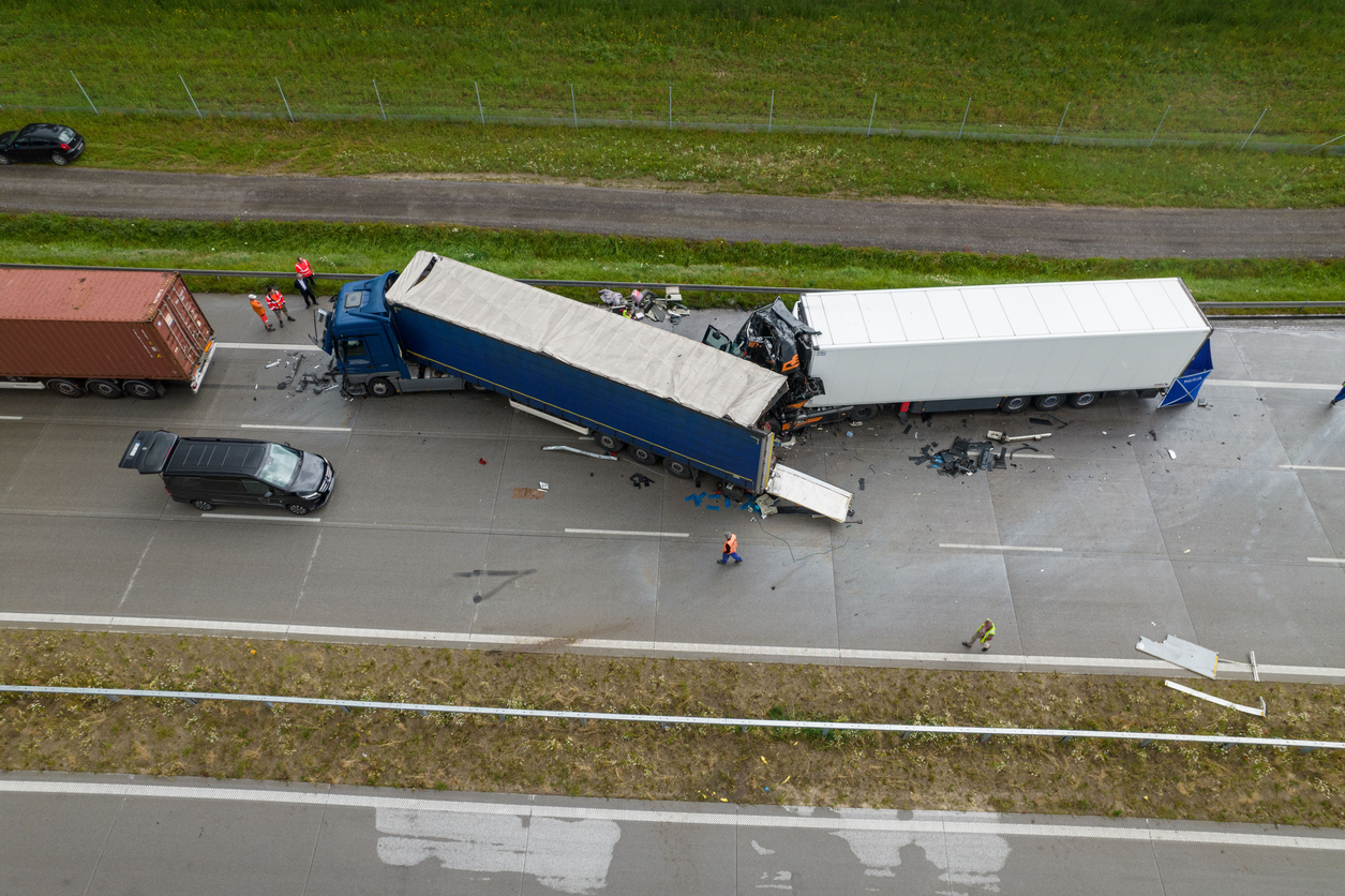 Direct overhead aerial view showing debris and heavy damage after a collision between two trucks on a motorway, Poland, Europe.